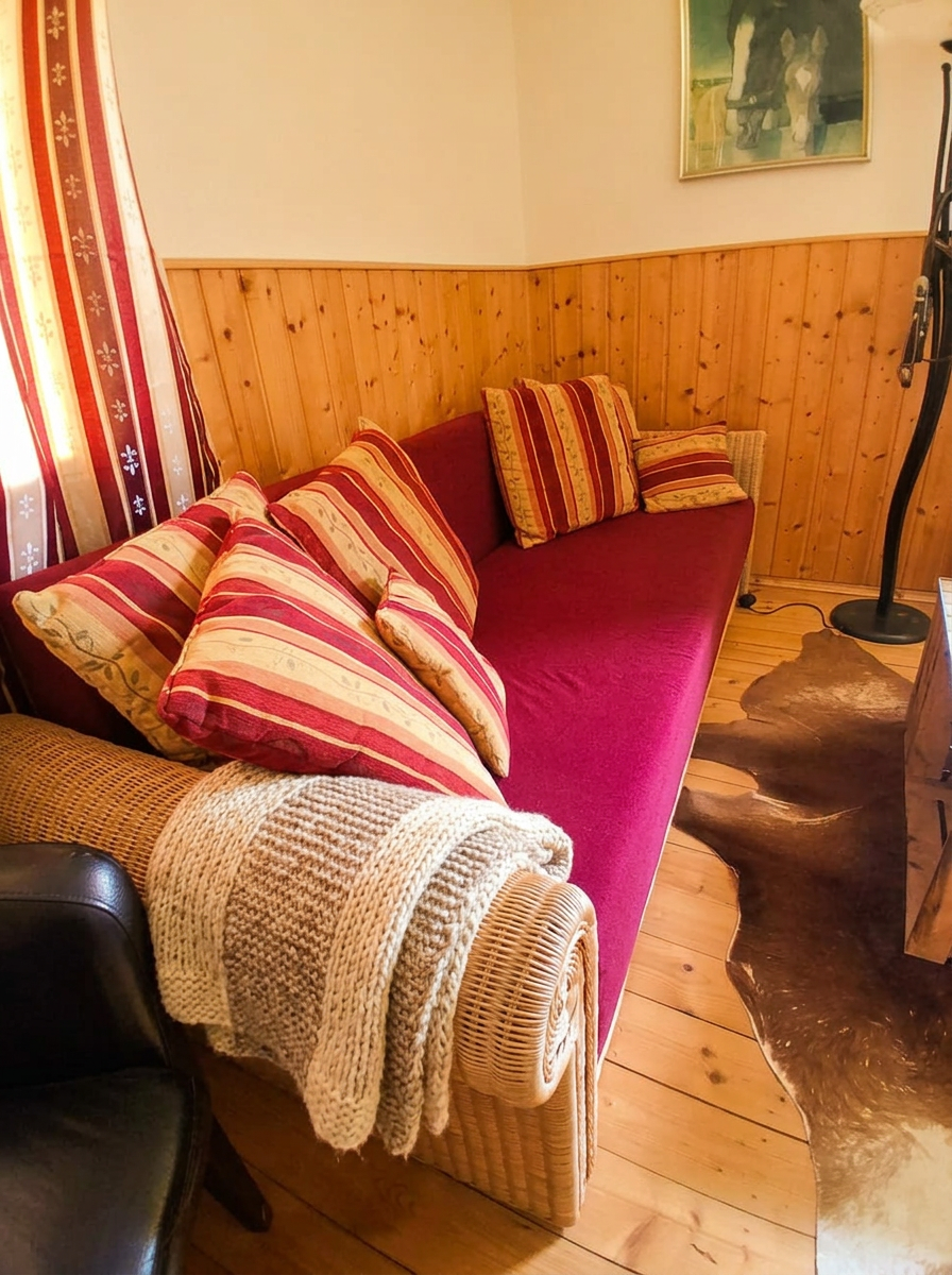 Gemütliche Sofaecke der Western-Wohnung mit Kissen und Kuscheldecke